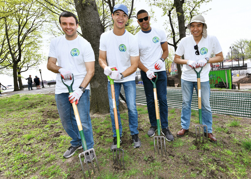 A group of people with garden rakes, working outside